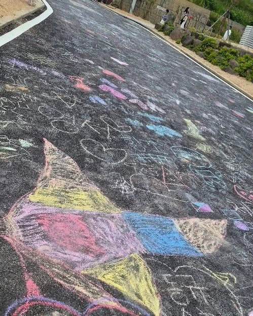Colorful chalk drawings covering an asphalt path