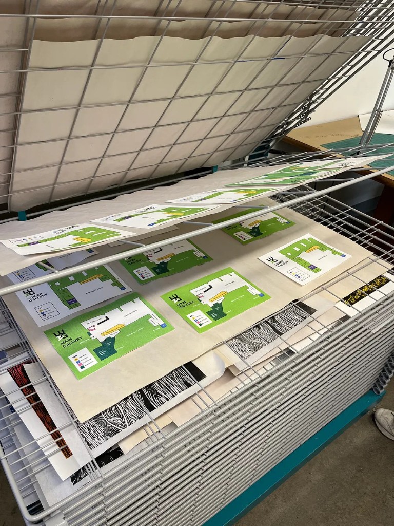 Printed LUAG maps drying on a studio wire rack