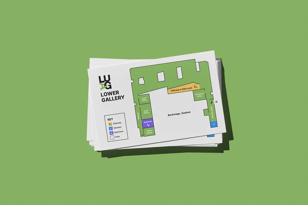 Printed LUAG Lower Gallery map cards stacked on a green surface
