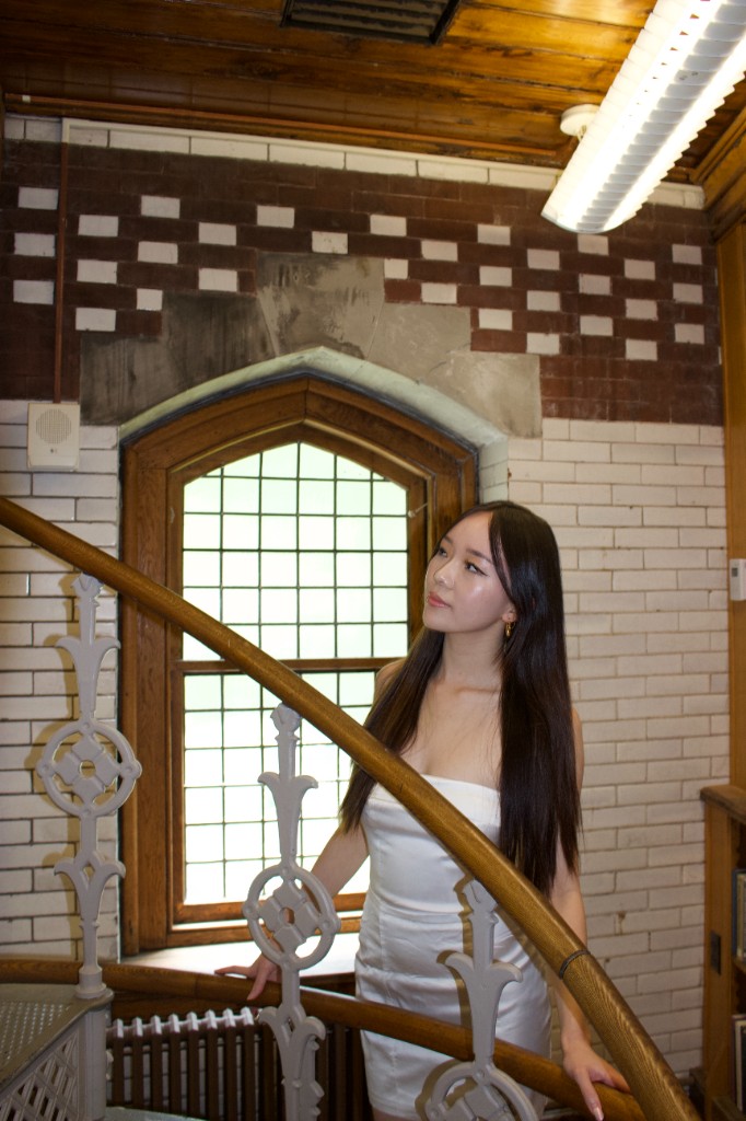 Person on a wooden staircase beside a gothic window