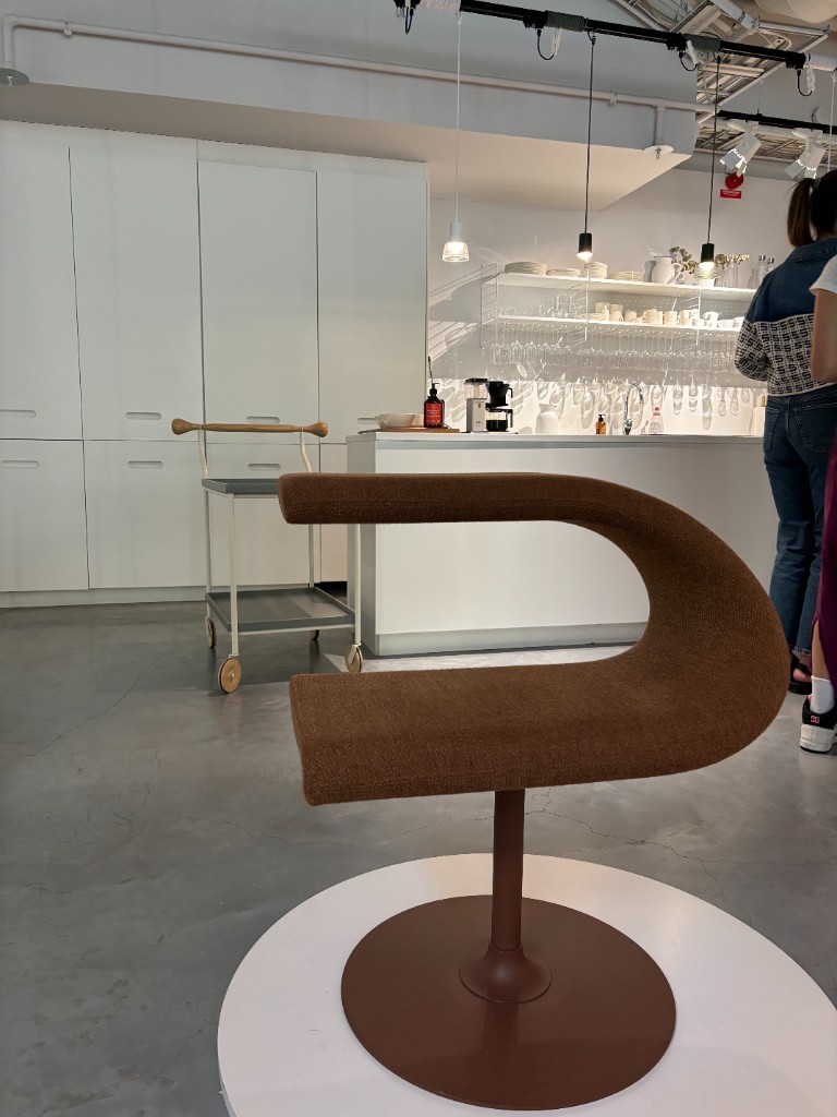 Brown sculptural pedestal chair in a showroom